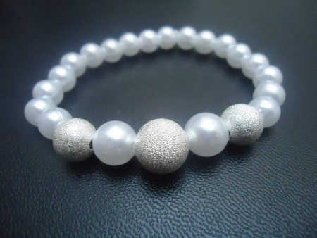 Pulseira de pérolas brancas e tres prateadas 